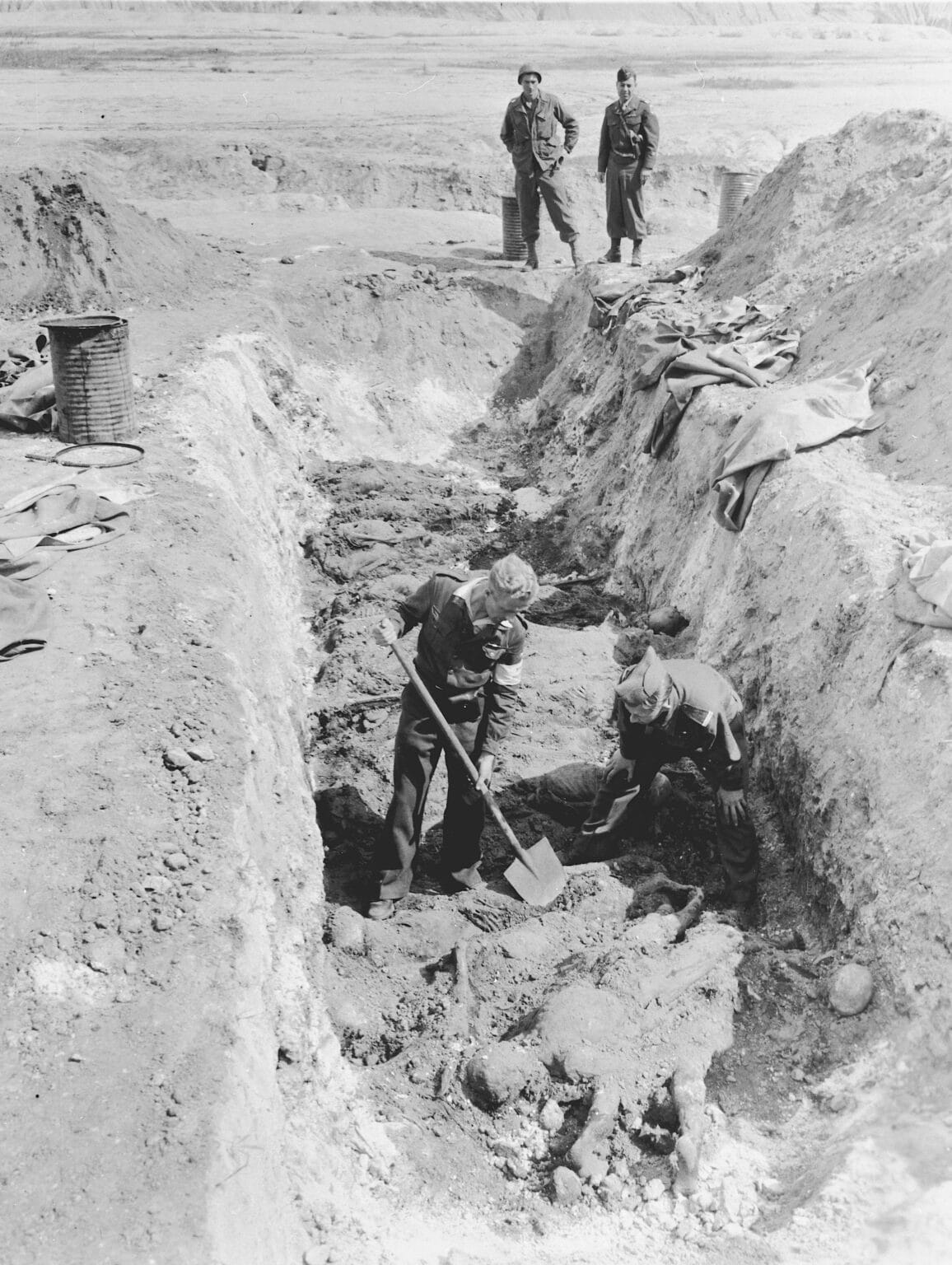 US-Soldaten öffnen ein deutschen Massengrab. Schwrz-Weiß Fotogrrafie.